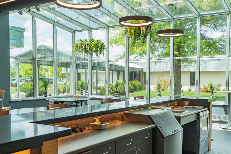 The Spoons Restaurant dining area, encompassed in windows from floor to ceiling, as seen from behind the bar.