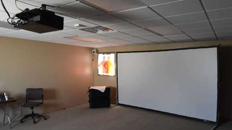 Indoor shooting simulator using a projector and large screen mounted to one wall in a classroom.