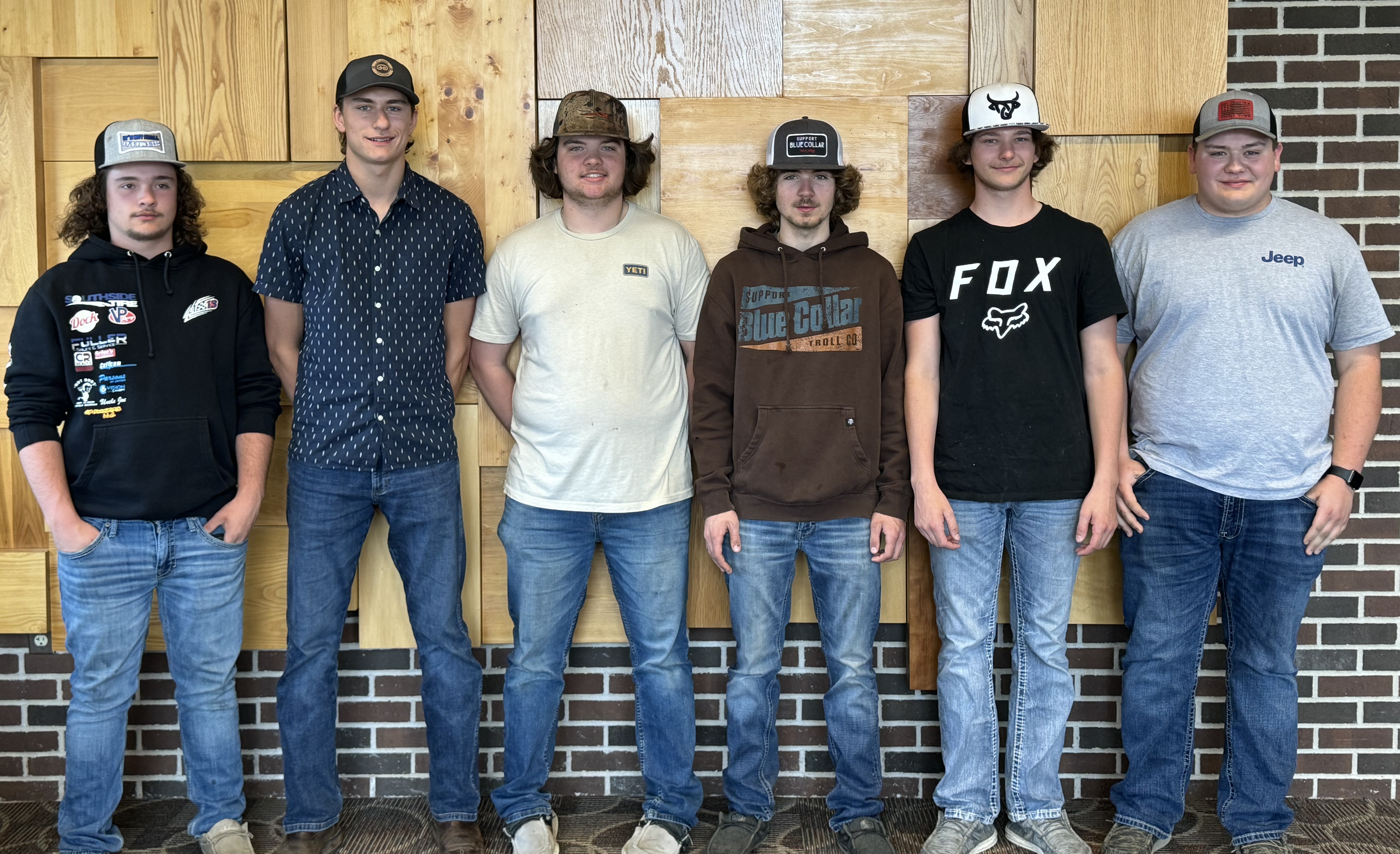 Antigo Basic Welding Academy Students posing while standing against a wall