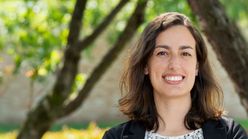 Kelly smiling while standing in the courtyard of the Wausau Campus.