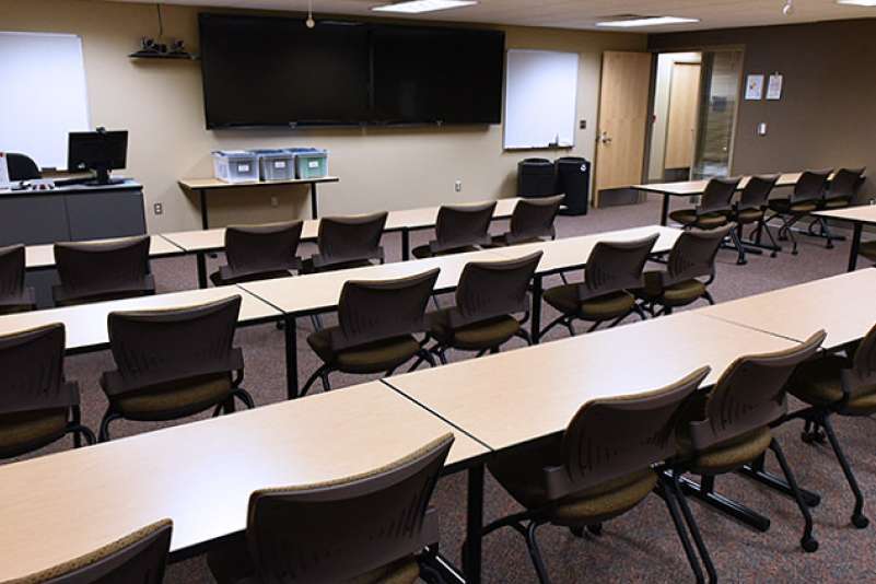 A training room with conference tables and chairs, as seen from the back of the room.