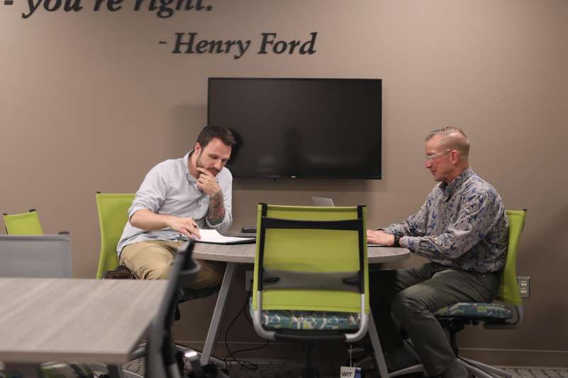 Two businessmen sitting at a table having a discussion.